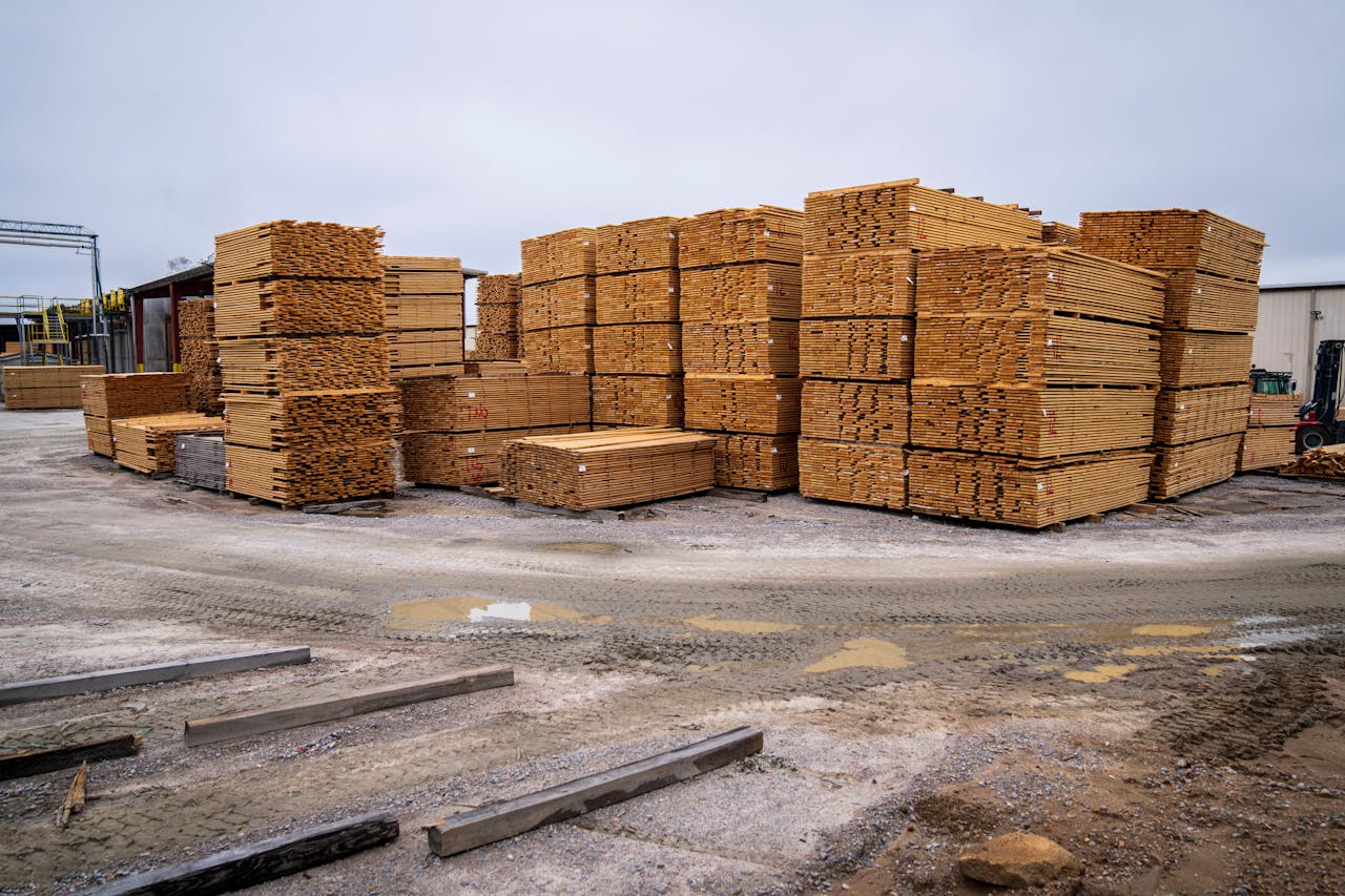 Piles of wooden planks prepared for distribution in an outdoor industrial site.